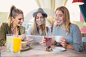 Female friends in cafe using digital tablet