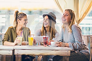 Female friends in cafe using digital tablet