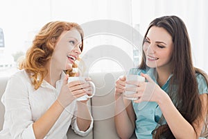 Female friends with coffee enjoying a conversation at home