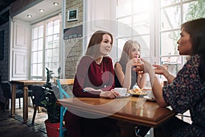 Female friends drinking coffee having a pleasant conversation in a cozy romantic restaurant