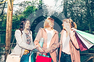 Female friends group having fun together at the city park after shopping