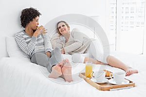 Female friends having breakfast in bed