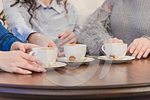 Female friends having a coffee together. Three women at cafe drinking, talking, laughing and enjoying their time