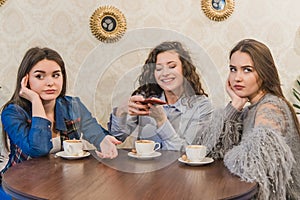 Female friends having a coffee together. Three women at cafe drinking, talking, laughing and enjoying their time