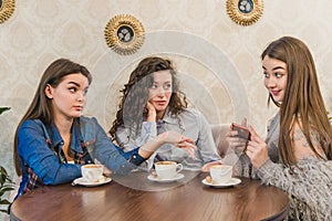 Female friends having a coffee together. Three women at cafe drinking, talking, laughing and enjoying their time