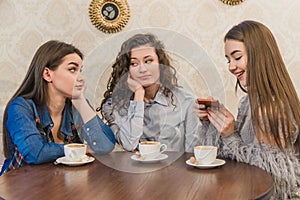 Female friends having a coffee together. Three women at cafe drinking, talking, laughing and enjoying their time