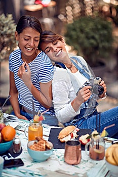 Female friends relaxed at the bar`s backyard. Quality friendship time together