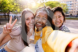 Female friendship concept with three diverse young women taking selfie outdoor