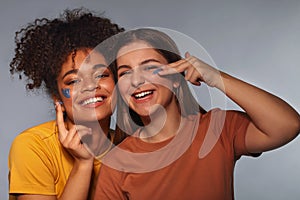 Female friendship. Two happy multi-ethnic teen girls friends having fun while applying face mask