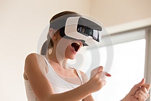 Female gamer wearing VR glasses playing virtual reality mobile g