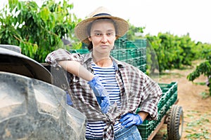 Female gardener with crossed hands posing at garden