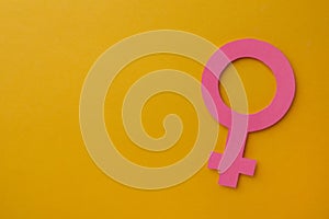Female gender sign and space for text on orange background, top view. Women`s health concept