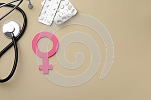 Female gender sign, stethoscope and pills on beige background, flat lay with space for text. Women`s health concept