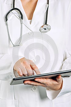 Female general medical practitioner using tablet computer