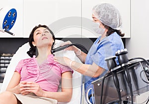 Female getting facial cryolipolyse treatment in cosmetic clinic