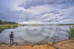 Female girl standing by a pond at sunrise