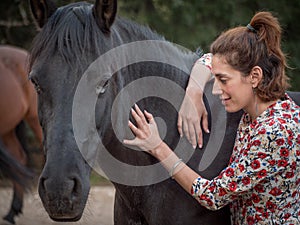 Female giving energy to black andalusian horse.