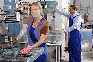 Female glazier working with glass drilling machine