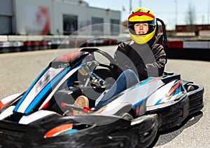 Female go-cart racer at kart circuit outdoors