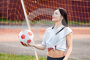 Female goalkeeper ball in his hands, standing at football goal