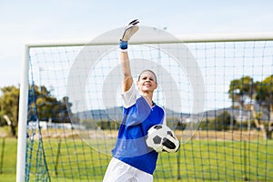 Female goalkeeper holding a ball and gesturing