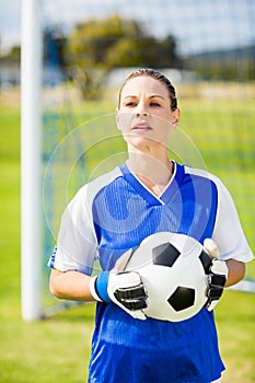 Female goalkeeper standing with ball