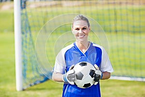 Female goalkeeper standing with ball