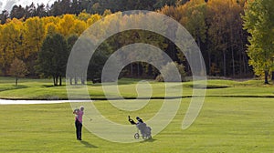 A female golf player swinging.