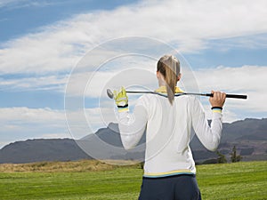 Female Golfer With Club On Golf Course