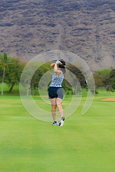 Female golfer hits golf ball