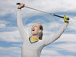 Female Golfer Holding Club Against Sky