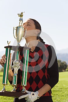 Female Golfer Kissing Her Trophy
