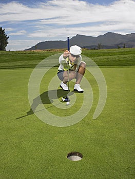 Female Golfer Lining Up A Putt