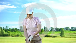 Female golfer ready to hit ball with club at meadow, training and hobby, sport