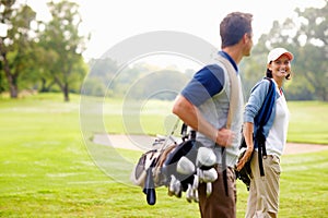 Female golfer smiling and looking at man. Focus on female golfer smiling and looking at man.