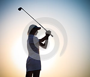Female golfer at sunset