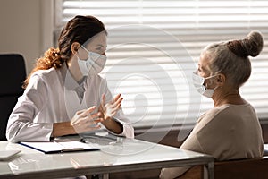 Female GP consult mature woman patient in hospital