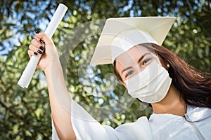 Female Graduate in Cap and Gown Wearing Medical Face Mask