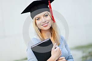 Female graduate holding book