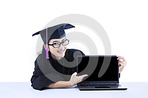 Female graduate pointing at empty laptop screen