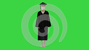 Female graduate student in a medical mask standing on a Green Screen, Chroma Key.