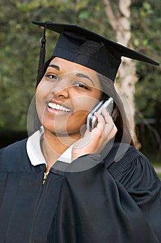 Female graduate using a cellular telephone