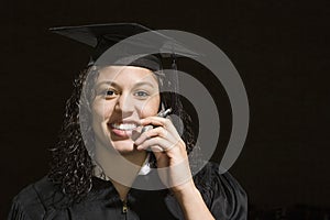 Female graduate using a cellular telephone