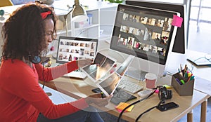 Female graphic designer looking photographs at desk