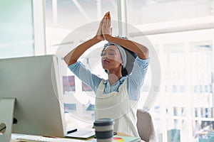 Female graphic designer performing yoga at desk