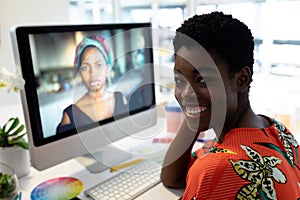 Female graphic designer smiling at desk in office