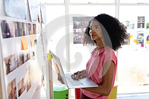 Female graphic designer using laptop in office