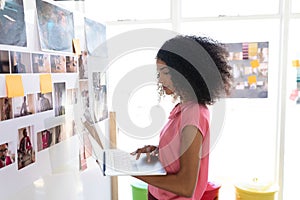 Female graphic designer using laptop in office