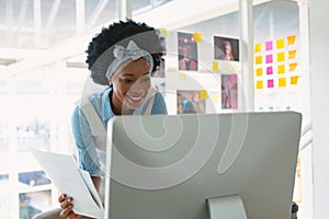 Female graphic designer working on computer at desk