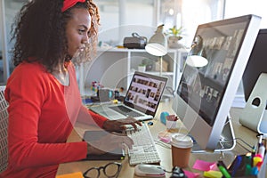 Female graphic designer working on desktop pc at desk